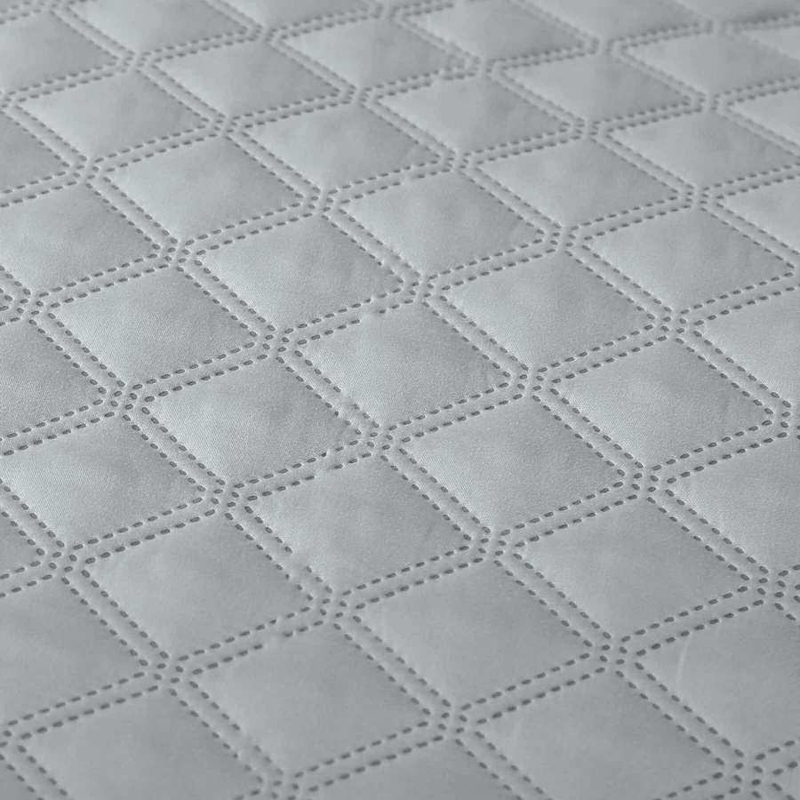 Szara pikowana poszewka dekoracyjna z pomponami Spod Igły i Nitki – upiększa sypialnię